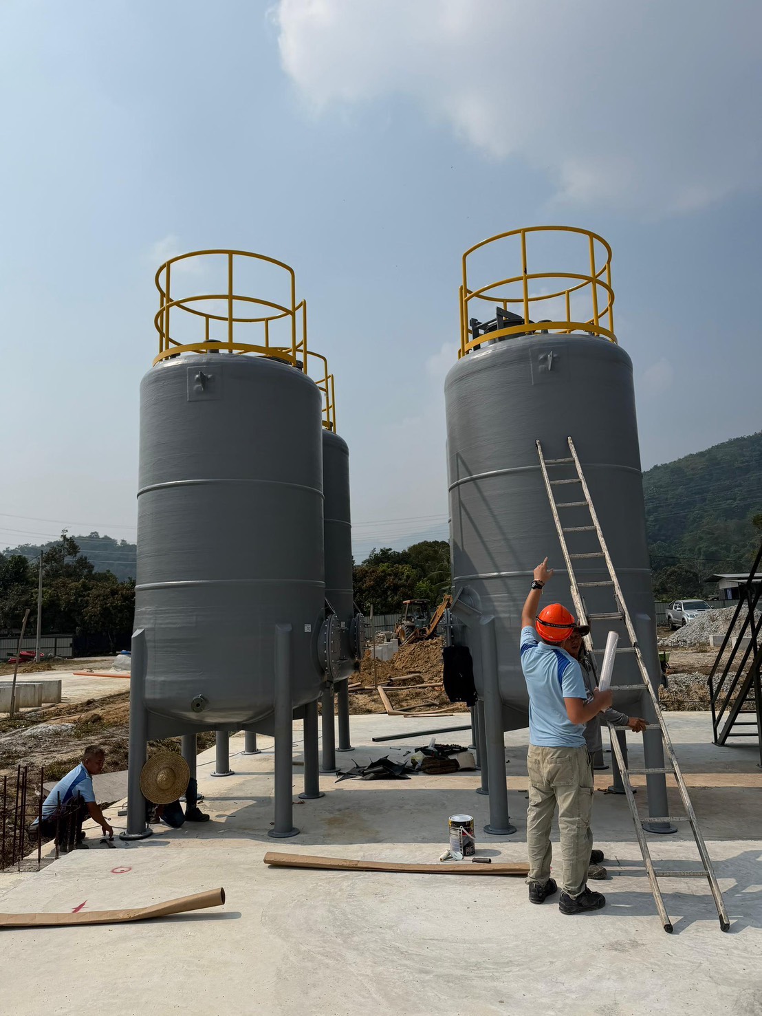 建設現場のタンクと作業者を別角度から撮影した写真